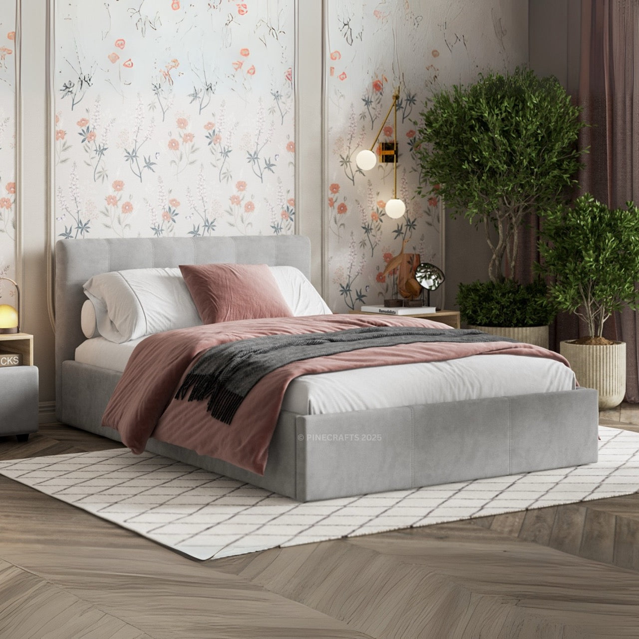 Gray upholstered bed with pink and gray bedding in a bedroom setting.